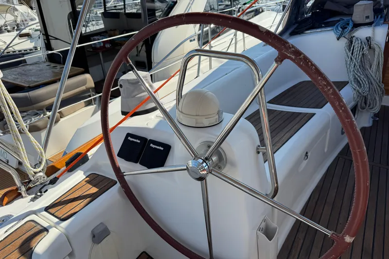 Eos Yacht Photos Pics Steering wheel of a 2008 Beneteau Oceanis 40 sailboat, featuring teak decking.
