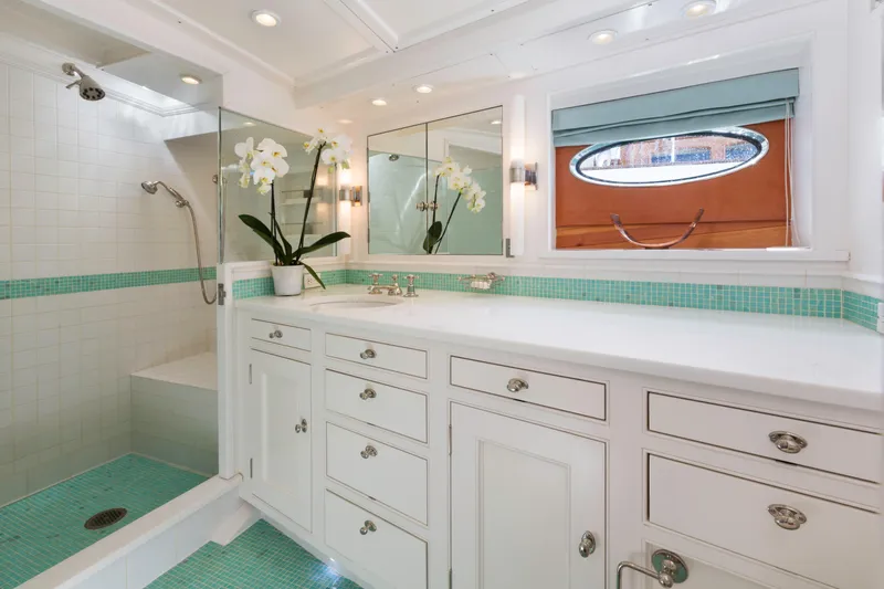 Bequia Yacht Photos Pics Luxurious boat bathroom with white cabinetry, turquoise accents, and elegant orchid decor, Brooklin Boat Yard 2009.