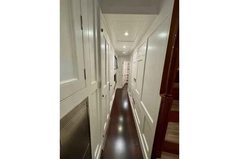 Bequia Yacht Photos Pics Narrow hallway inside 2009 Brooklin Boat Yard model, featuring elegant wood paneling and soft lighting.