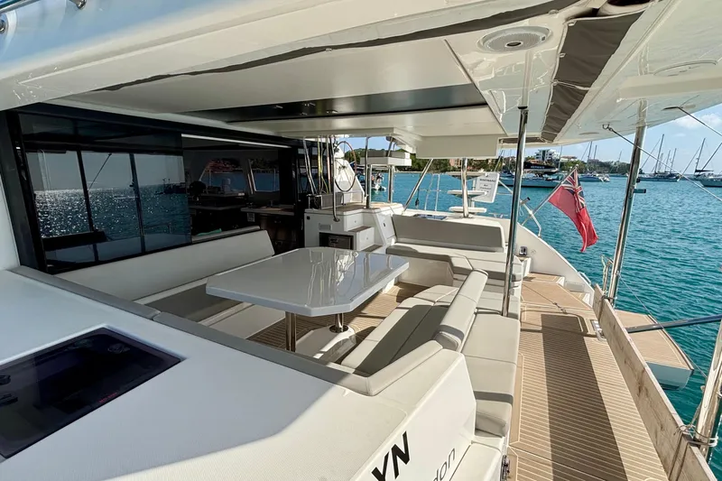  Yacht Photos Pics Luxurious 2022 Leopard 45 yacht deck with seating, table, and ocean view.