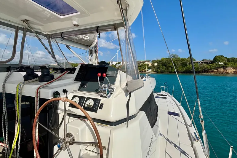  Yacht Photos Pics 2022 Leopard 45 yacht cockpit with steering wheel, controls, and ocean view.