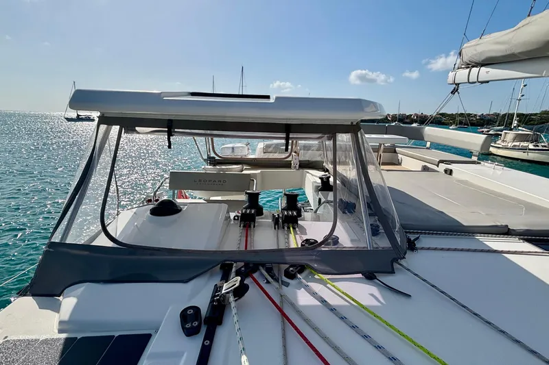  Yacht Photos Pics 2022 Leopard 45 catamaran deck with clear canopy, sailing in sunny waters.