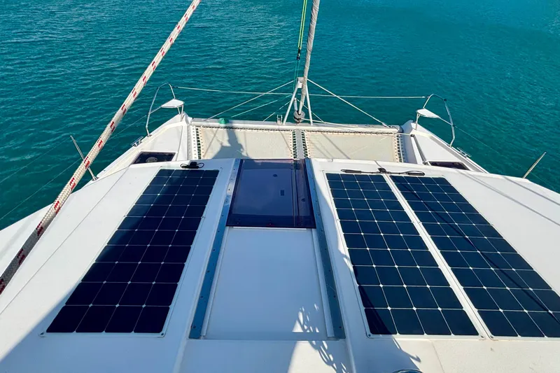  Yacht Photos Pics 2022 Leopard 45 catamaran with solar panels on deck, sailing on clear blue water.