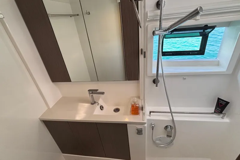  Yacht Photos Pics Modern bathroom in 2022 Leopard 45 yacht with sink, mirror, and ocean view window.