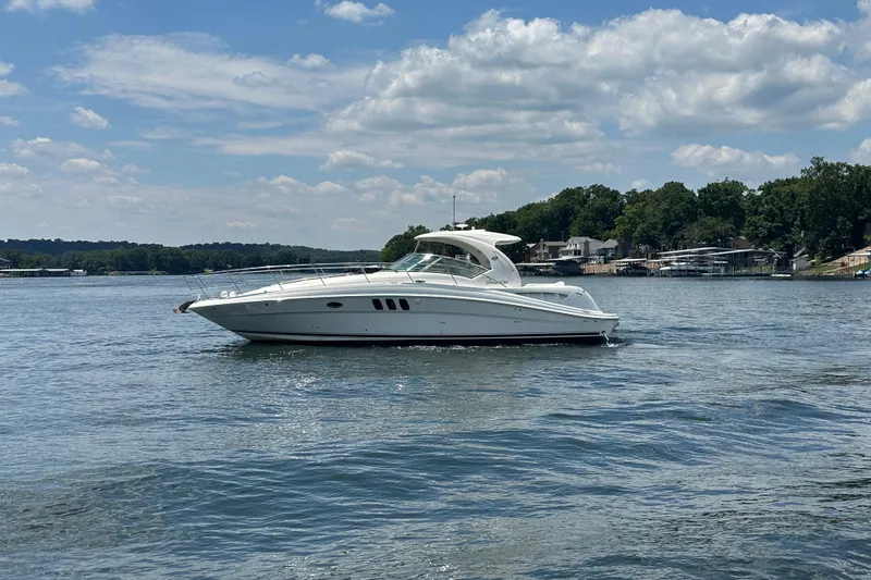  Yacht Photos Pics 2007 Sea Ray 40 Sundancer yacht cruising on a serene lake under a partly cloudy sky.