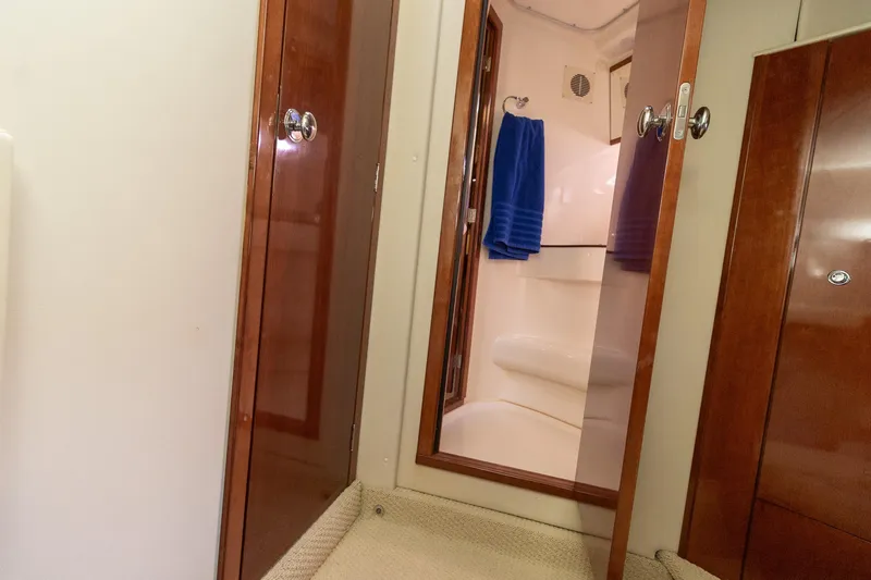  Yacht Photos Pics Interior of 2009 Meridian 391 Sedan yacht bathroom with wooden doors and blue towel.