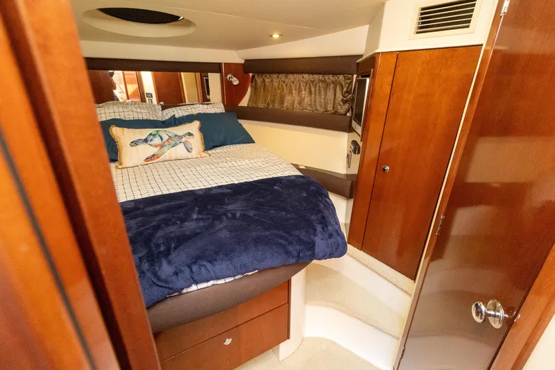  Yacht Photos Pics Luxurious 2009 Meridian 391 Sedan bedroom with cozy bedding and elegant wood finishes.