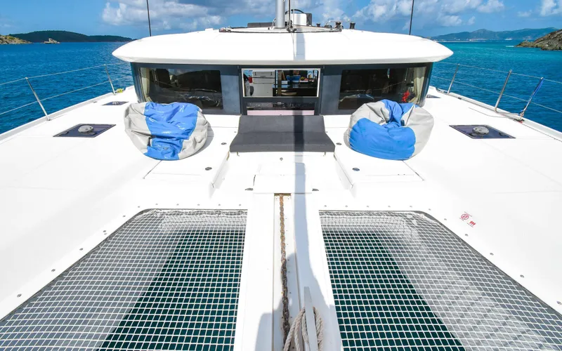Celavie Yacht Photos Pics 2021 Lagoon 46 catamaran deck with netting, blue sea, and clear sky.