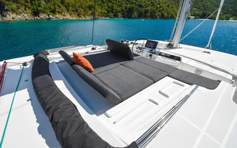 Celavie Yacht Photos Pics Luxurious Lagoon 46 catamaran deck with sun loungers, 2021 model, overlooking serene blue waters.