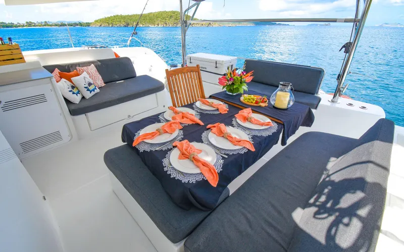 Celavie Yacht Photos Pics Luxurious Lagoon 46 catamaran deck set for dining, overlooking serene blue waters.