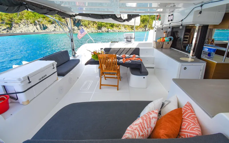 Celavie Yacht Photos Pics Luxurious 2021 Lagoon 46 catamaran interior with seating, dining area, and scenic ocean view.
