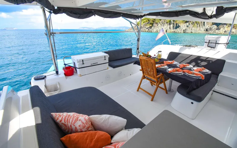 Celavie Yacht Photos Pics Luxurious Lagoon 46 catamaran interior, 2021 model, with elegant seating and dining area by the sea.