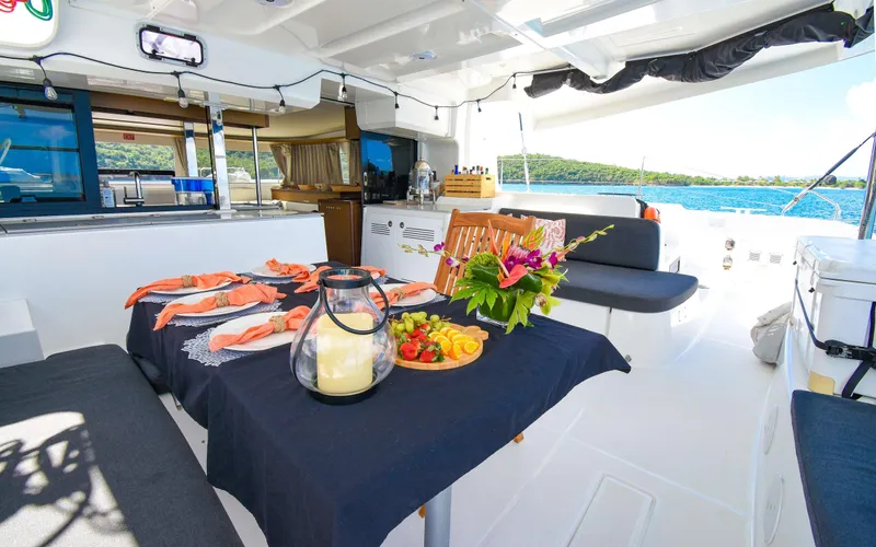 Celavie Yacht Photos Pics Luxurious Lagoon 46 catamaran interior with dining setup, featuring elegant tableware and scenic ocean view.