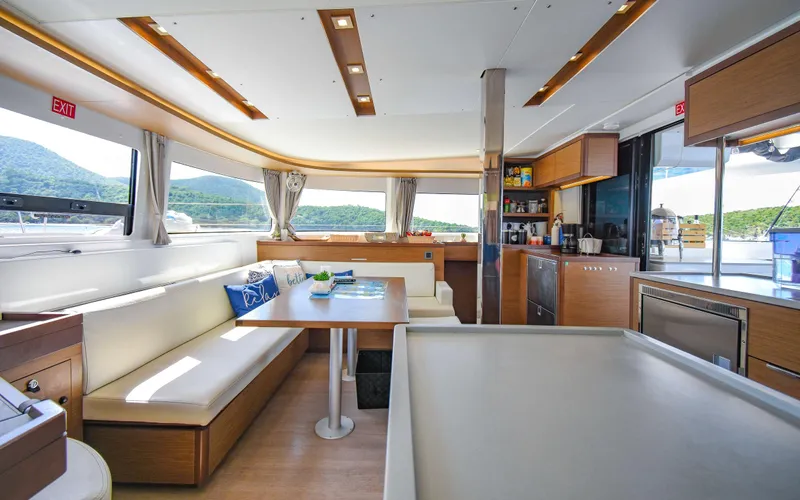 Celavie Yacht Photos Pics Luxurious interior of 2021 Lagoon 46 catamaran with modern kitchen and seating area.
