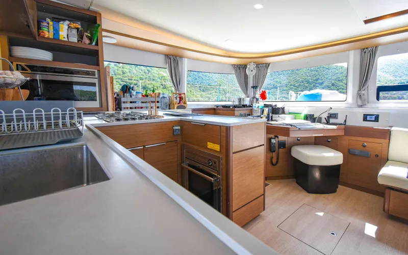 Celavie Yacht Photos Pics Modern kitchen interior of 2021 Lagoon 46 yacht with scenic window views.