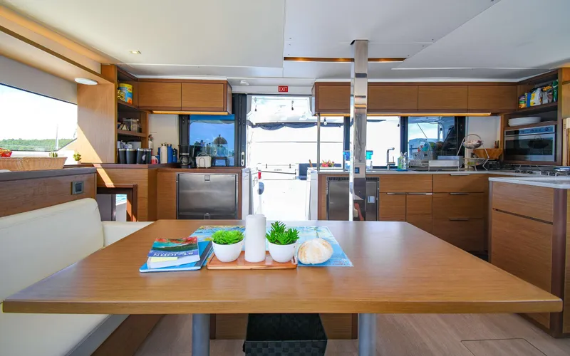 Celavie Yacht Photos Pics Interior of 2021 Lagoon 46 catamaran with modern kitchen and dining area.