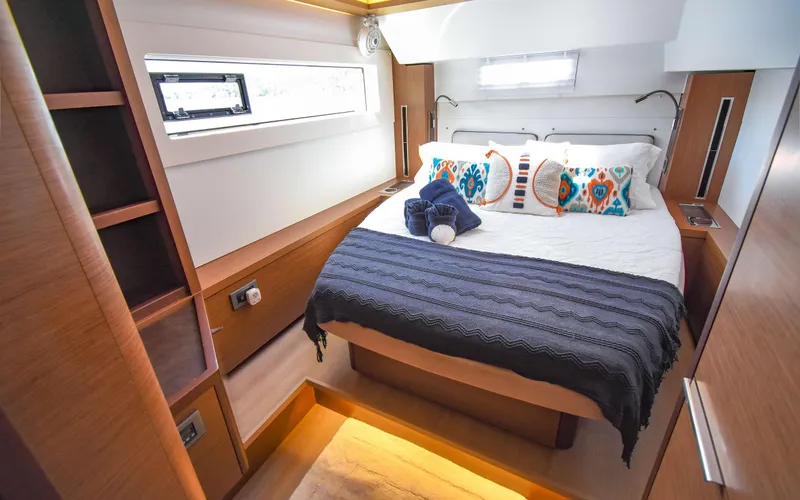Celavie Yacht Photos Pics Luxurious cabin interior of 2021 Lagoon 46 yacht with cozy bed and modern decor.