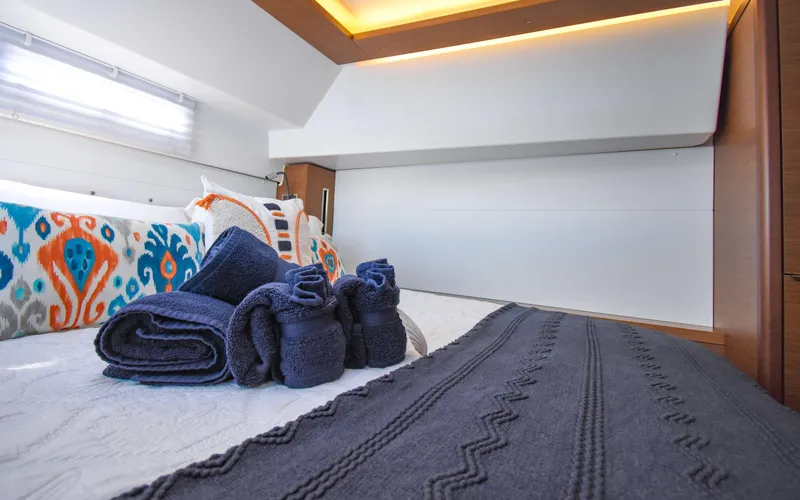 Celavie Yacht Photos Pics Luxurious cabin interior of 2021 Lagoon 46 yacht with neatly arranged towels.
