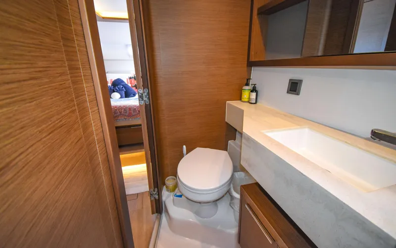 Celavie Yacht Photos Pics Bathroom interior of 2021 Lagoon 46 yacht, featuring modern fixtures and wooden accents.