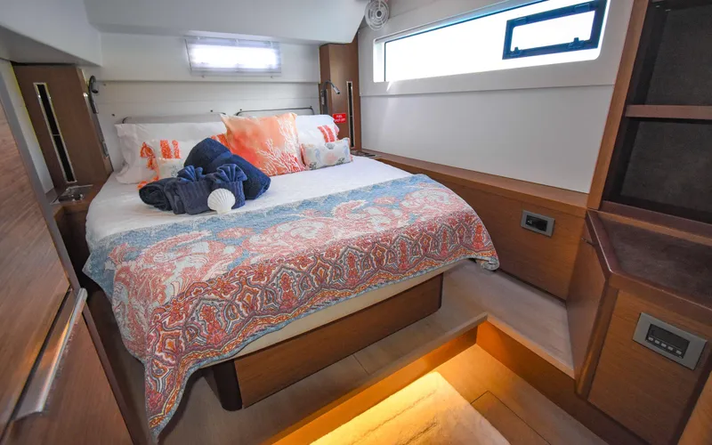 Celavie Yacht Photos Pics Luxurious bedroom interior of 2021 Lagoon 46 yacht with colorful bedding and modern design.