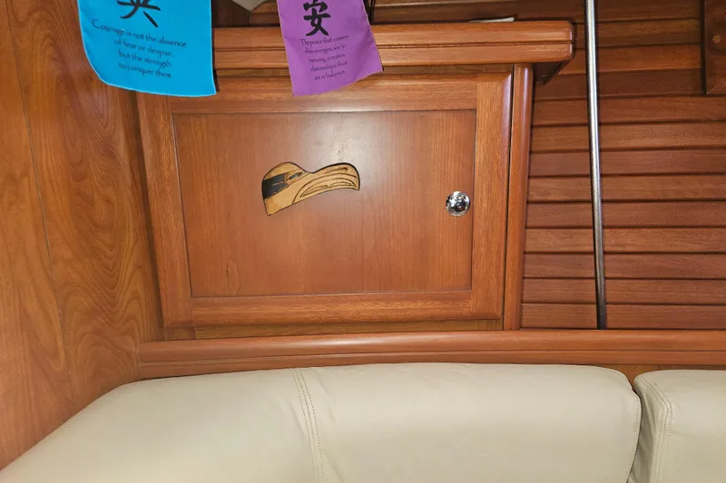 Soirse Yacht Photos Pics Wooden interior of 2013 Marlow-Hunter 50 aft cabin with decorative cabinet and colorful flags.