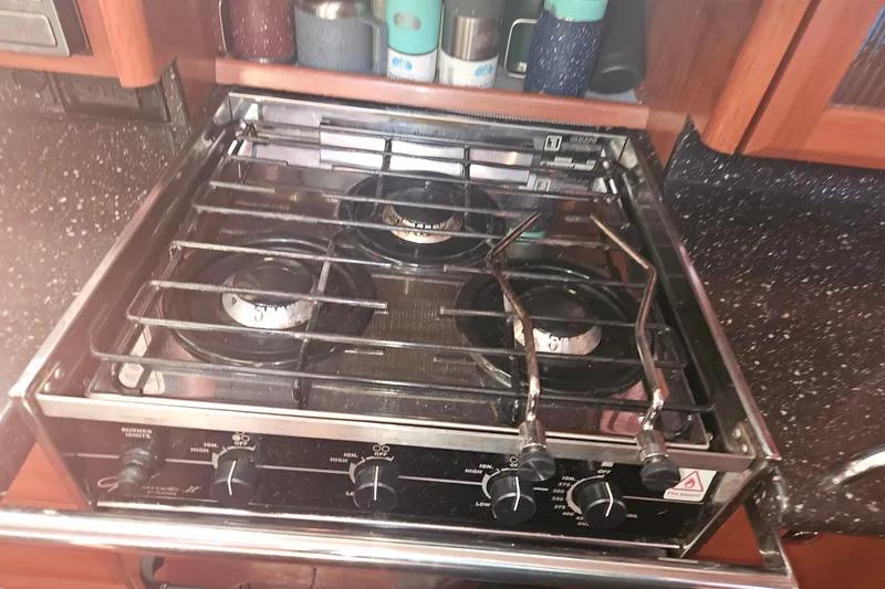 Soirse Yacht Photos Pics Stove in 2013 Marlow-Hunter 50 aft cabin yacht kitchen, with black countertop and wooden cabinets.