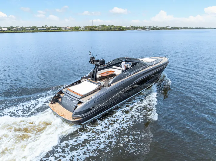 Wolverine Yacht Photos Pics 2015 Riva 63 Virtus yacht cruising on a calm lake under a clear blue sky.