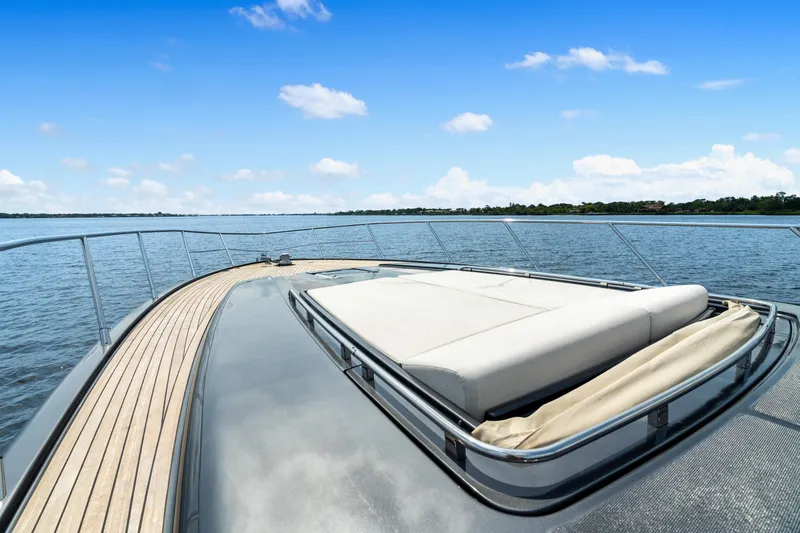 Wolverine Yacht Photos Pics Luxurious 2015 Riva 63 Virtus yacht deck with sunbed, overlooking serene waters.