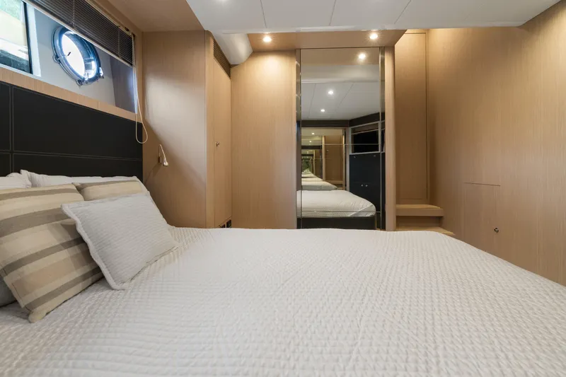 Wolverine Yacht Photos Pics Luxurious bedroom interior on 2015 Riva 63 Virtus yacht, featuring elegant wood paneling.