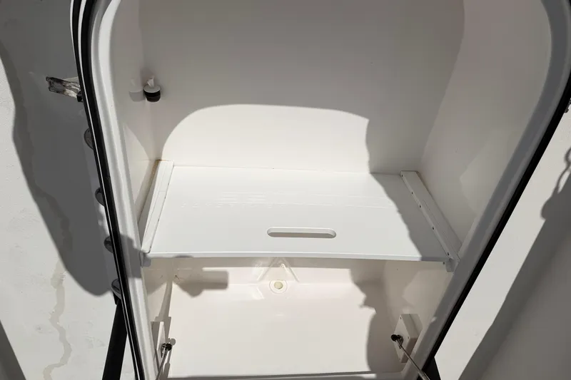  Yacht Photos Pics Open storage compartment in 2021 Twin Vee 310 CC GF boat, featuring a white interior.