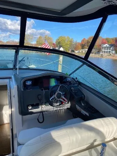  Yacht Photos Pics 2023 Regal 33 Express boat cockpit with scenic lake view and autumn foliage.