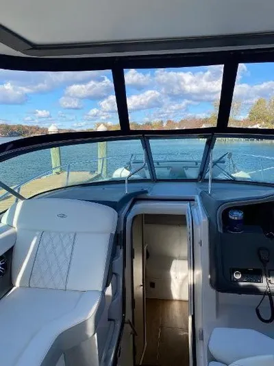  Yacht Photos Pics 2023 Regal 33 Express boat interior with white seating, docked by a scenic lake.