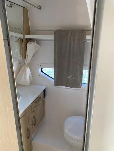  Yacht Photos Pics 2023 Regal 33 Express bathroom with modern fixtures and window.