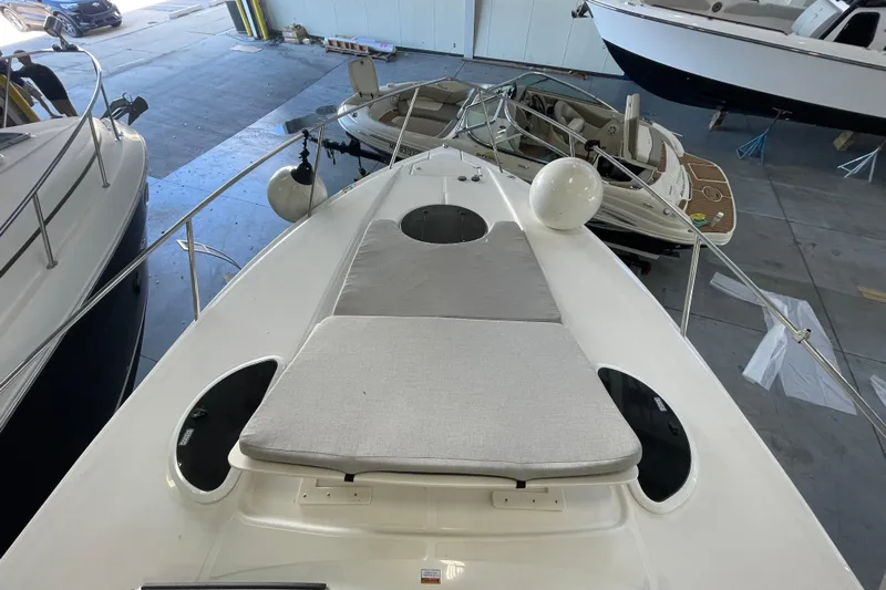  Yacht Photos Pics 2023 Regal 33 Express boat with sunpad, docked indoors among other vessels.