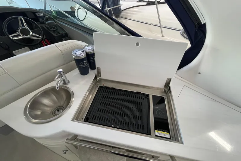  Yacht Photos Pics 2023 Regal 33 Express boat interior with sink, grill, and steering wheel.