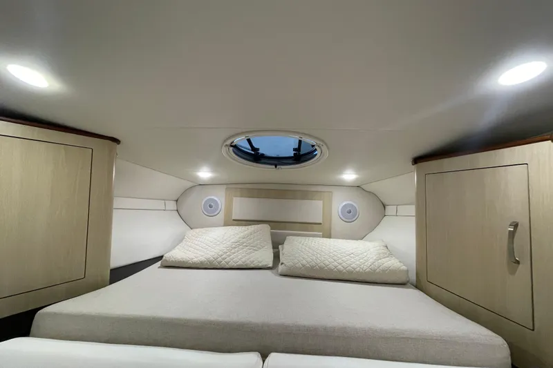  Yacht Photos Pics Interior cabin of 2023 Regal 33 Express yacht with cozy bedding and modern lighting.