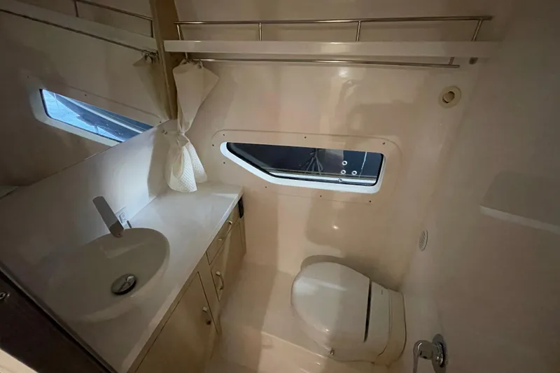  Yacht Photos Pics 2023 Regal 33 Express boat bathroom with sink, toilet, and window.