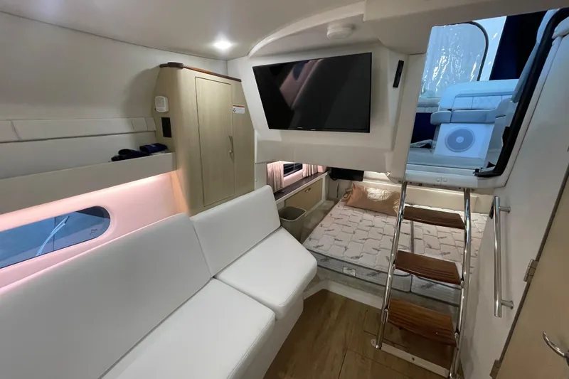  Yacht Photos Pics 2023 Regal 33 Express yacht interior with modern seating, TV, and wooden steps.