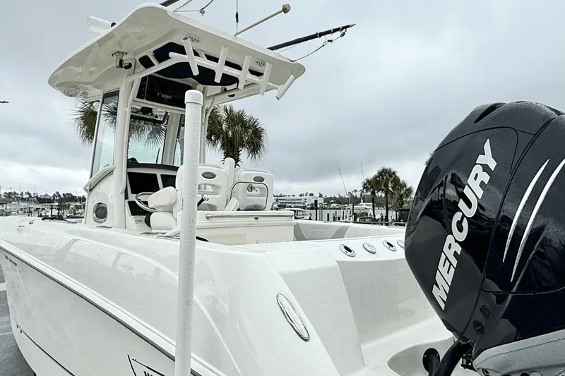  Yacht Photos Pics 2015 Boston Whaler 280 Outrage boat with Mercury engine, docked under cloudy skies.
