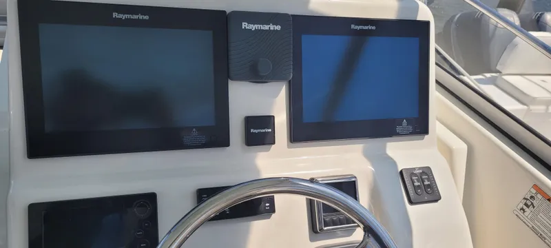 Dos Suenos Yacht Photos Pics Century 30 boat dashboard with Raymarine displays, steering wheel, and control panel, 2015 model.