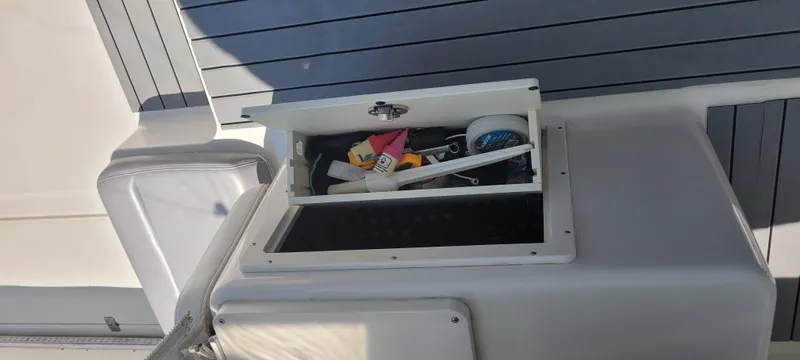 Dos Suenos Yacht Photos Pics Open storage compartment on a 2015 Century 30 boat, containing various tools and accessories.