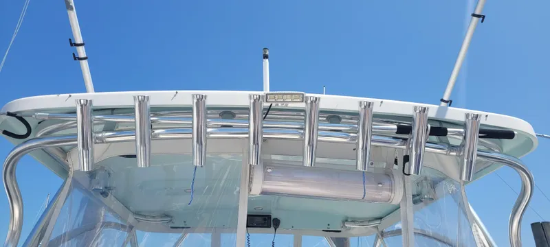 Dos Suenos Yacht Photos Pics Century 30 boat, 2015 model, featuring rod holders and a clear canopy against a blue sky.