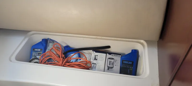 Dos Suenos Yacht Photos Pics Storage compartment with Yamalube oil, orange extension cord, and filter box in a 2015 Century 30 boat.