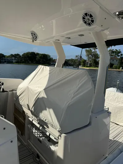  Yacht Photos Pics 2020 Regal 33 SAV boat interior with covered equipment, docked by a scenic waterfront.