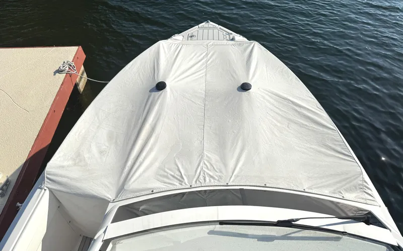  Yacht Photos Pics 2020 Regal 33 SAV boat with cover, docked on calm water.