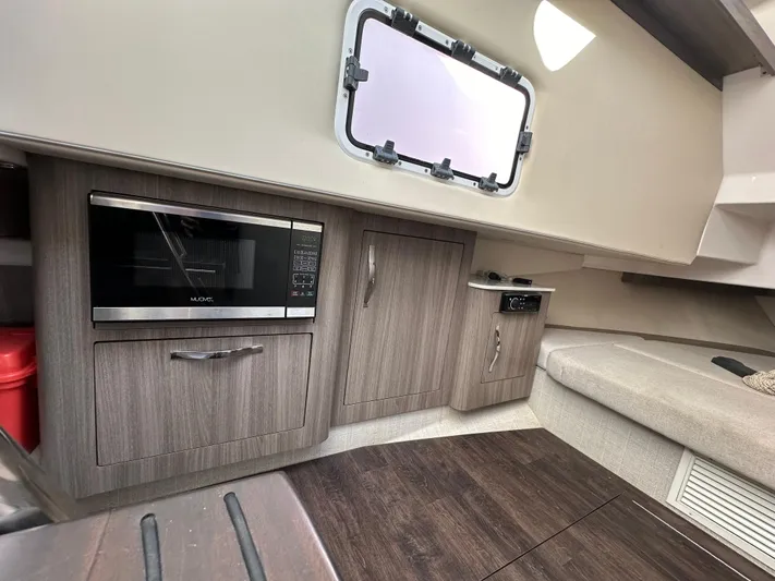  Yacht Photos Pics 2020 Regal 33 SAV interior with microwave, cabinets, and seating area.