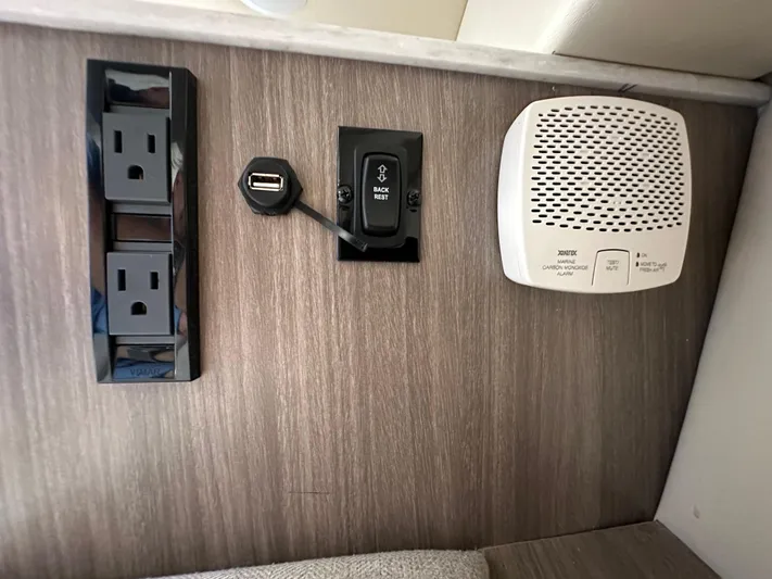  Yacht Photos Pics Power outlets, USB port, and speaker on a 2020 Regal 33 SAV boat interior wall.