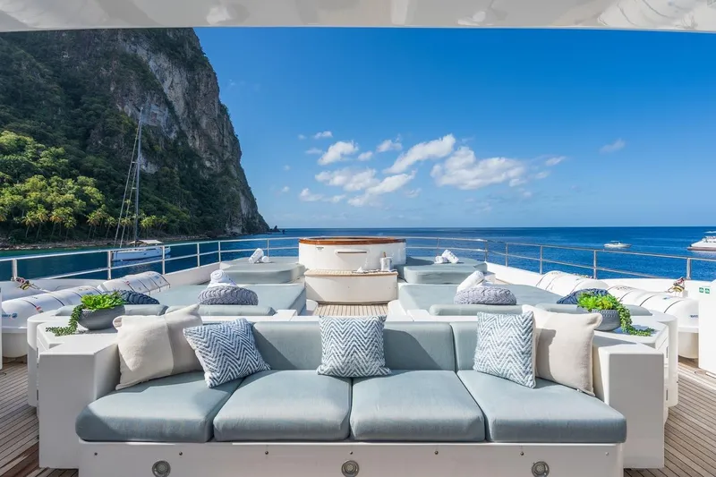 Oceanos Yacht Photos Pics Luxurious Mondomarine motor yacht deck with plush seating, ocean view, and scenic cliffs, 2006 model.