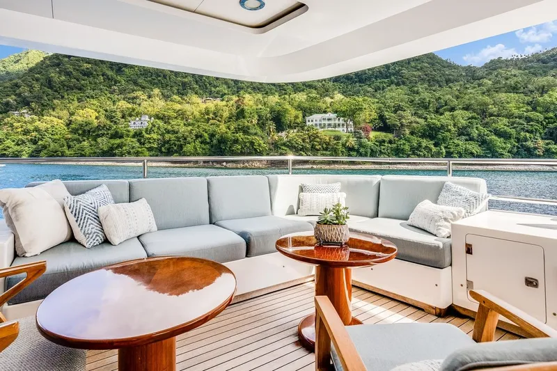 Oceanos Yacht Photos Pics Luxurious Mondomarine motor yacht deck with elegant seating, wooden tables, and scenic ocean view.