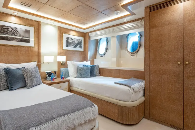 Oceanos Yacht Photos Pics Luxurious Mondomarine motor yacht bedroom with twin beds, elegant wood paneling, and nautical decor.
